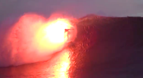 炎を噴き出しながら波に乗るサーファー